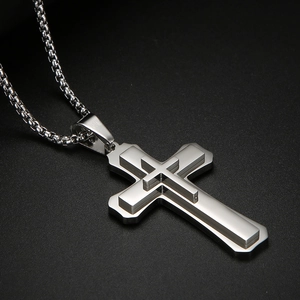 Gros plan d'un collier pendentif double croix en argent avec une chaîne à mailles polie