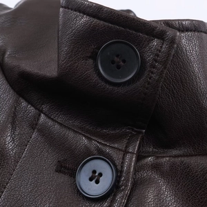 Detailed macro view of dark brown faux leather texture with buttons and stitching