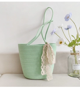 Close-up of light green woven cotton rope tote bag with elegant lace ribbon detail