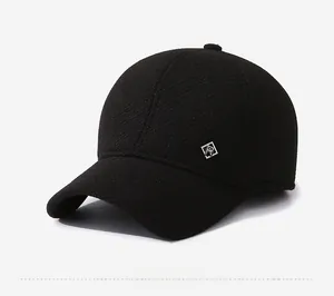 Detail of black winter baseball cap featuring textured knit fabric and square metal logo