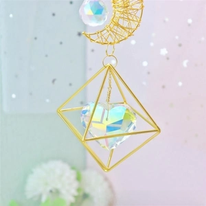 Detail of moon and heart crystal suncatcher with golden frame and faceted beads
