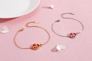 Detail of adjustable stainless steel heart charm bracelets in gold and silver finish