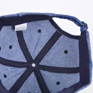 Detail view of the 100% cotton label and reinforced stitching inside the denim baseball cap