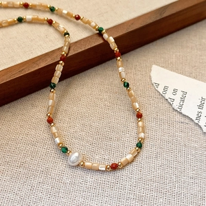 Detail of colorful beads and a central Baroque pearl on a French style necklace