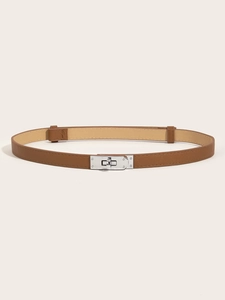 Detail of caramel leather skinny belt featuring a silver metal turn-lock buckle and texture