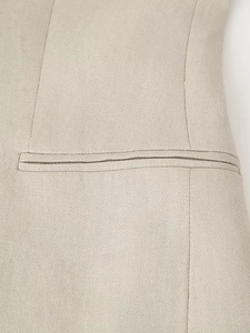 Detail of light beige woven fabric texture and precise stitching on the vest welt pocket
