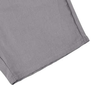 Detailed macro view of light gray linen fabric texture and double-needle stitching on polo set