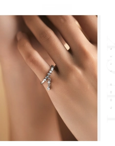 Detail of s925 silver ring featuring sparkling round cubic zirconia and a movable charm