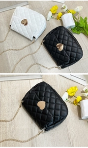 Detail view of quilted cross-body bags with heart-shaped metal buckles and gold chains