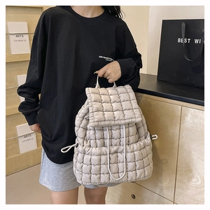 Dettaglio dello zaino a nuvola trapuntato beige con chiusura a coulisse e texture