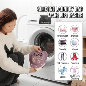 Lilac silicone laundry bag for delicate bras being placed into a washing machine drum