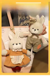 Dettagli di ciondoli a forma di coniglio in peluche con vestito e camicia a righe