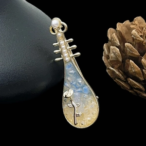 Broche pipa dorée vintage avec rose sculptée et perles sur fond de pierres