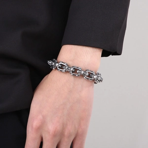 Detail of retro punk silver skull link chain bracelet worn on a man's wrist