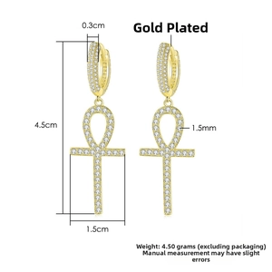 Macro shot of gold-plated Ankh cross earrings with micro-paved white cubic zirconia