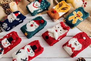 Detail of soft coral fleece Christmas socks with festive 3D animal patterns and textures