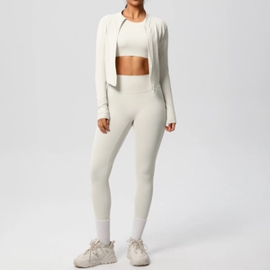 Three-piece ivory yoga set including zip jacket, crop top, and high waist leggings detail