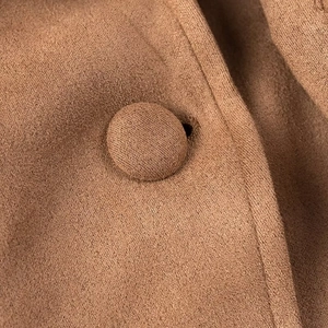 Detail shot of brown faux suede fabric texture and matching fabric-covered button