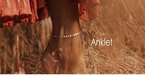 Detailed view of bohemian style golden chain anklet worn on model in outdoor natural light