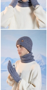 Close-up of blue knitted winter set featuring beanie with leather patch, scarf, and gloves