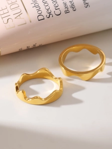 Macro detail of wave-shaped 18K gold plated stainless steel rings for stacking