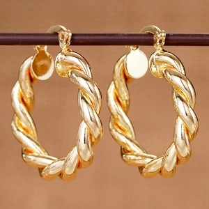 Detailansicht goldener gedrehter Creolen mit eleganter Spiralstruktur und Textur