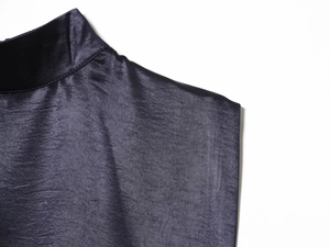 Détail de l'encolure d'une robe en satin bleu foncé avec des empiècements de dentelle