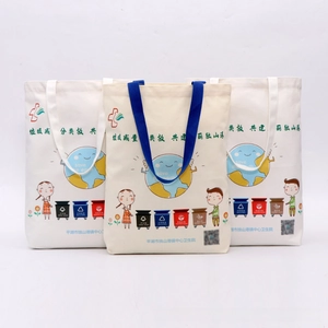 Detailed view of eco-friendly canvas tote bags with green theme printing and durable handles