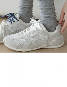 Détail de chaussettes grises en coton peigné avec côtes verticales et pois noirs