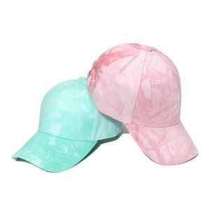 Dettaglio di cappellini da baseball tie-dye menta e rosa con texture in twill di cotone