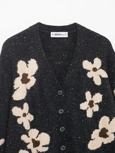 Detailansicht der Strickjacke mit Blumenmuster, V-Ausschnitt und Knöpfen in Dunkelgrau