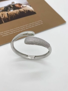 Detailed close-up of a silver-plated teardrop bangle featuring micro-pave cubic zirconia
