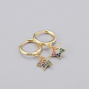 Macro detail of gold star earrings featuring colorful zircon stones on a gray background