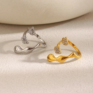Detailed view of wave-shaped rings with sparkling zircons in gold and silver finish