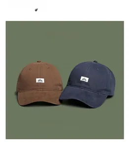 Detailed display of brown and navy blue soft top baseball caps with a mountain logo patch
