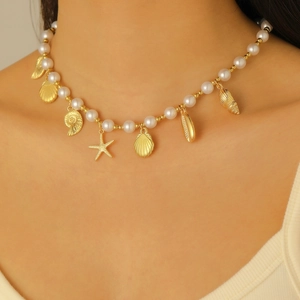 Detail der Boho-Halskette mit Perlenimitaten, goldenen Seesternen, Muschel und Schnecke
