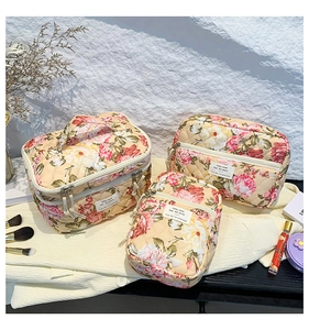 Three-piece floral quilted makeup bag set with beige base and elegant flower pattern