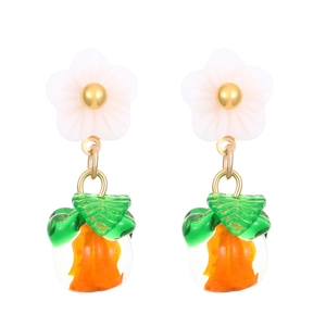 Detailed shot of orange fruit earrings with white flower studs and green leaves
