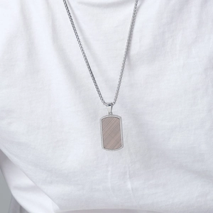 Men's silver stainless steel military dog tag necklace on a male model with white t-shirt