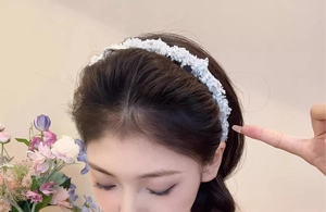 Gros plan du serre-tête tressé blanc en tissu pelucheux porté par un mannequin asiatique