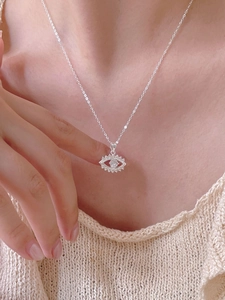 Close-up of S925 silver devil eye pendant necklace with zircon on a female model