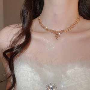 Elegant gold wheat leaf pendant necklace worn by a model in a soft white sweater