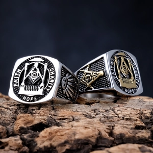 Stainless steel Freemason rings featuring Faith Hope Charity engravings on wood surface