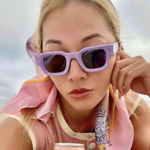 Close-up of light purple thick square sunglasses with dark lenses on a fashion model