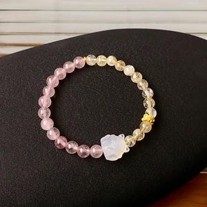 Detailed shot of Rutilated Quartz and Strawberry Quartz beads with a fox charm