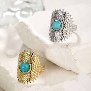 Macro shot of gold and silver plated cutout rings featuring turquoise natural stones