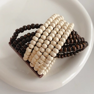 Detail of multi-layer coconut shell wood bead stretch bracelet in dark brown and cream