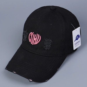 Détail d'une casquette en coton noir vieilli avec broderie de lettres en cœur rose