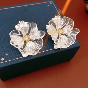 Primo piano dettagliato di orecchini a fiore in resina con cristalli dorati