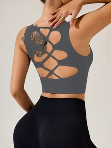Détail du dos croisé d'un débardeur de yoga gris foncé avec leggings noirs taille haute